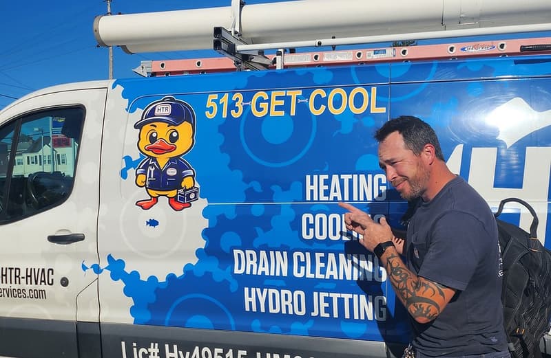 Technician pointing at branded HVAC service van